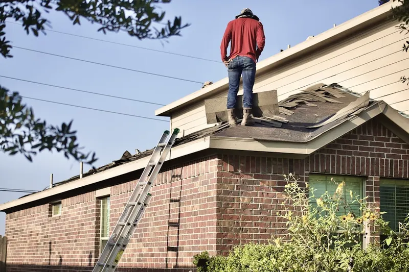 Professional roofer working on a residential roof in Melrose East Side